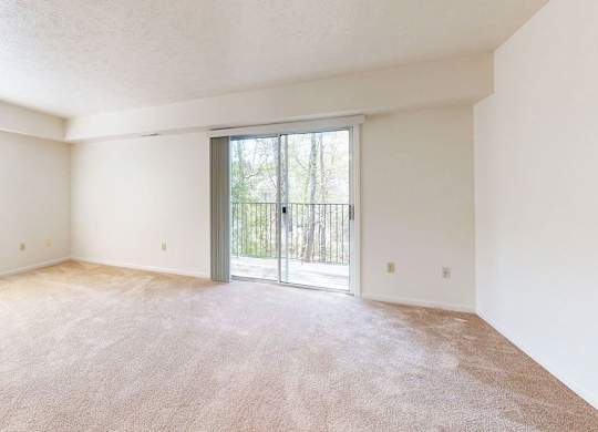 an end living room with a sliding glass door to a balcony at Fieldstream Apartment Homes, Iowa