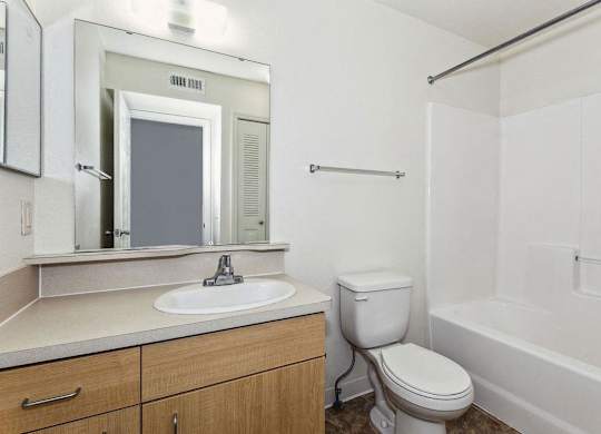 a bathroom with a sink toilet and a mirror at Fieldstream Apartment Homes, Iowa