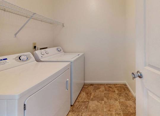 a washer and dryer in a laundry room with a door at Fieldstream Apartment Homes, Iowa