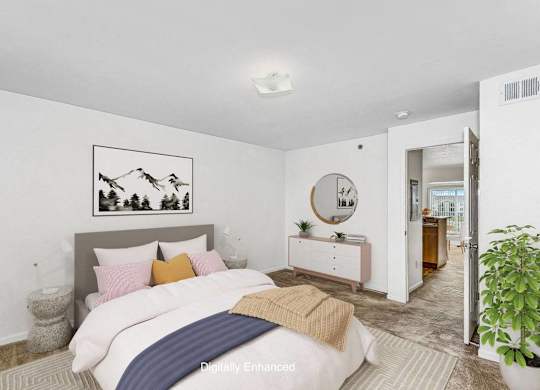 a bedroom with a bed and a mirror in the corner at Fieldstream Apartment Homes, Iowa