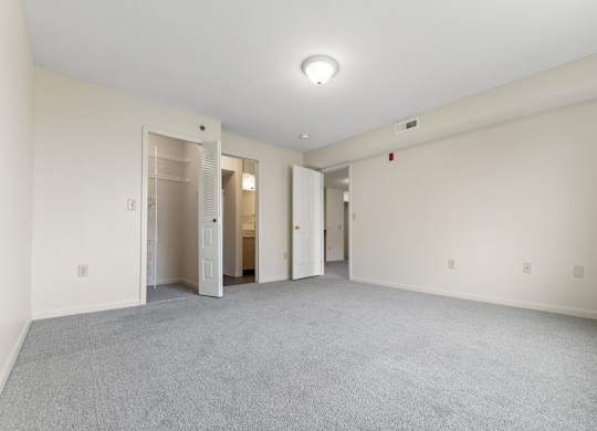 A large empty bedroom with an attached bathroom and a walk-in closet at Fieldstream Apartment Homes in IA 50023