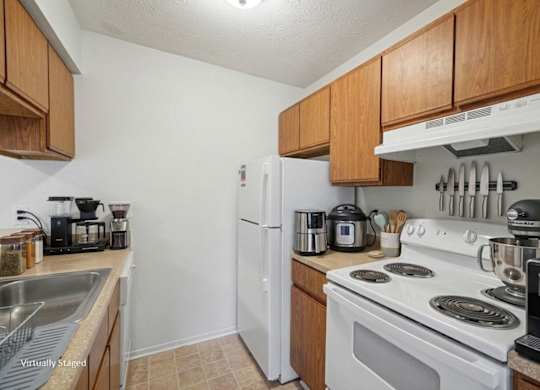 A kitchen with a white stove top oven and a white refrigerator.