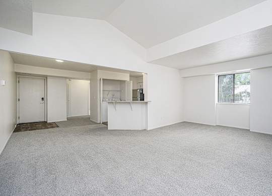 End living and dining room with a high ceiling and carpet at Foxwood and The Hermitage in Portage, MI