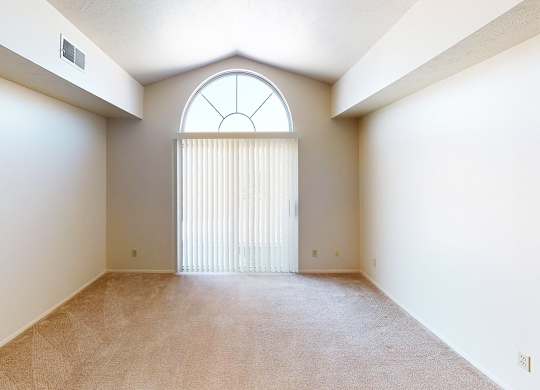 A living room with a large window and a cathedral ceiling at Foxwood and The Hermitage, Portage, MI