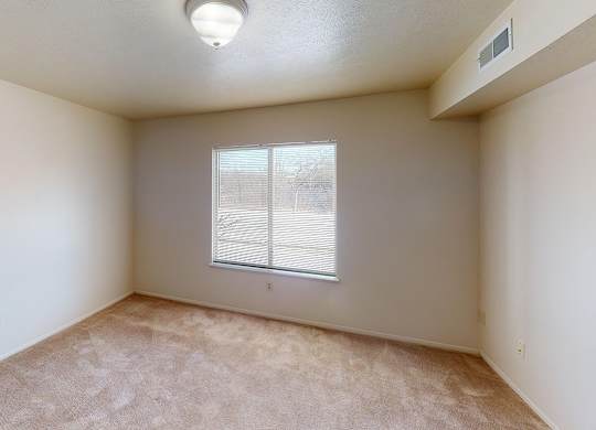 A bedroom with a window and carpeted floor at Foxwood and The Hermitage, Portage, MI