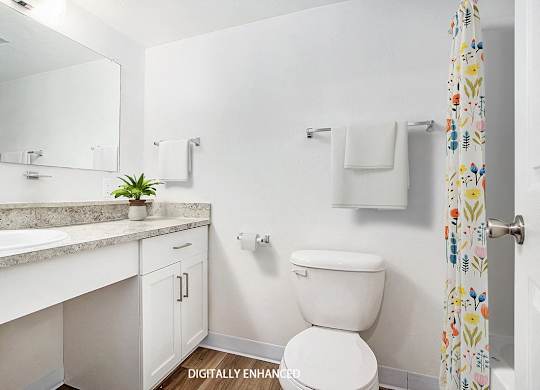 A modern bathroom with a vanity and large mirror at Glenn Valley Apartments in Battle Creek, MI