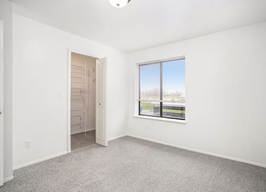 a bedroom with a large window and a walk in closet at Glenn Valley Apartments in Battle Creek, MI