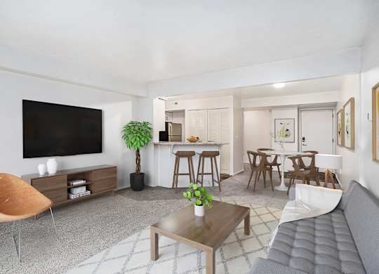 A living room with a grey sofa, wooden coffee table, and a television at Glenn Valley Apartments in Battle Creek, MI