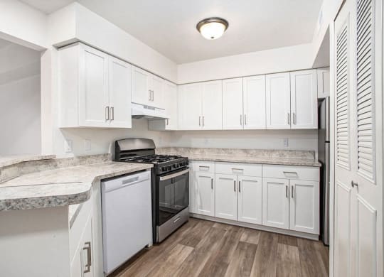 an upgraded kitchen with white cabinets and hard surface flooring at Glenn Valley Apartments in Battle Creek, MI
