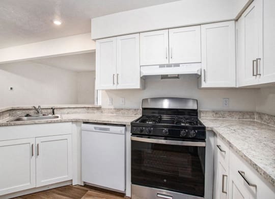 an upgraded kitchen with white cabinets and a stove and a dishwasher at Glenn Valley Apartments in Battle Creek, MI