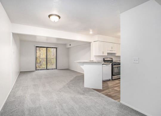 a living room and kitchen with a door to a balcony at Glenn Valley Apartments in Battle Creek, MI