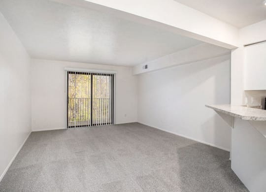 an upgraded living room with a door to a balcony at Glenn Valley Apartments in Battle Creek, MI