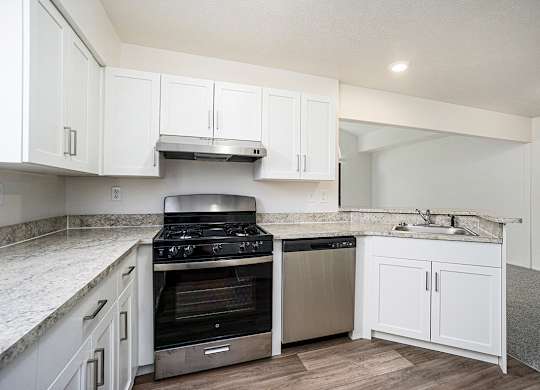A kitchen with a stove, a dishwasher and breakfast bar at Glenn Valley Apartments, Battle Creek, MI, 49015