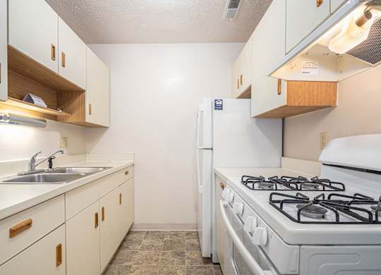 Kitchen with white appliances at Granada Apartments, Jackson, 49202