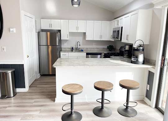 A community building kitchen with white cabinets and a breakfast bar at Granada Apartments, Jackson