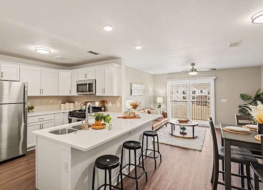A kitchen with white cabinets and a stainless steel refrigerator at The Grove Apartment Homes, Nebraska