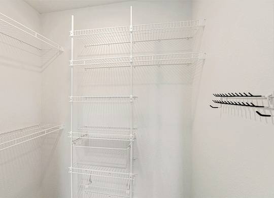 A walk-in closet with wardrobe organizers at The Grove Apartment Homes, Nebraska, 68512