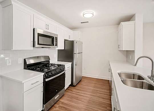 A kitchen with white cabinets and stainless steel appliances at The Grove Apartment Homes in Lincoln, NE