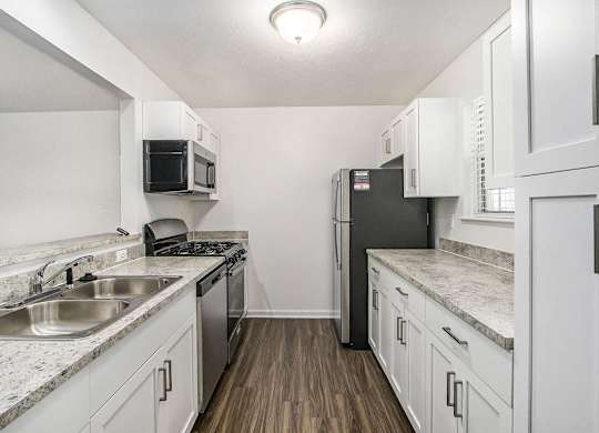 a kitchen with stainless steel appliances and white cabinets at Gull Prairie/Gull Run Apartments and Townhomes, Kalamazoo