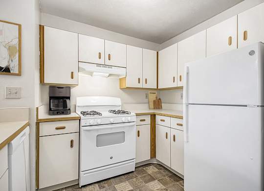 A kitchen with white appliances and wooden cabinets at Gull Prairie/Gull Run Apartments and Townhomes, Michigan, 49048