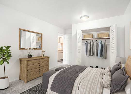 A bedroom with a bed, dresser, mirror and a closet at Hampton Lakes Apartments, Michigan, 49534