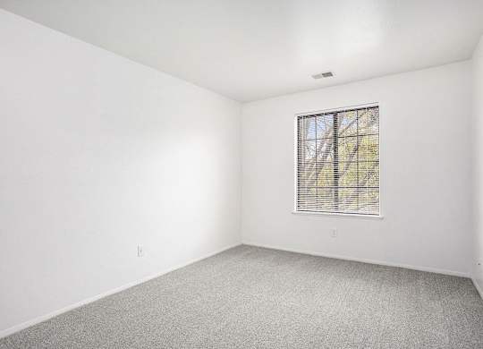 a bedroom with a window and carpet at Hampton Lakes Apartments, Michigan, 49534