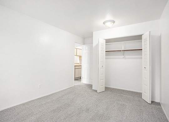 a bedroom with a closet with open doors at Hampton Lakes Apartments, Michigan, 49534