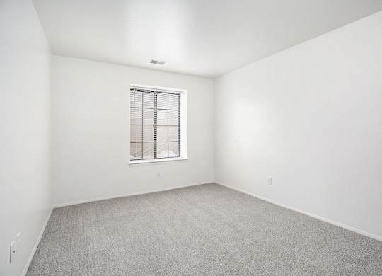 a spacious bedroom with a window at Hampton Lakes Apartments, Michigan, 49534