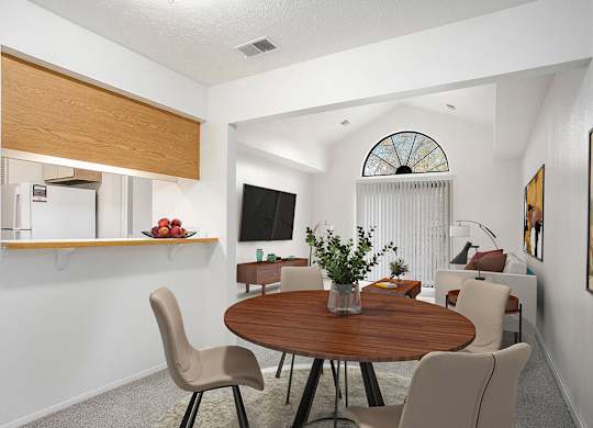 A dining room leading to a living room with a cathedral ceiling at Hampton Lakes Apartments, Michigan, 49534