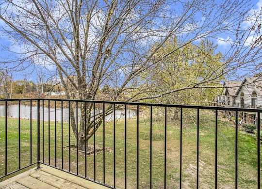a balcony view with a tree and a pond at Hampton Lakes Apartments, Michigan, 49534