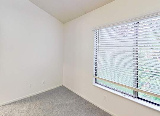 A master bedroom with a window covered by white blinds and an ensuite bathroom at Foxwood and The Hermitage, Portage, MI