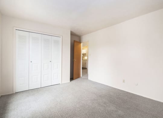 a bedroom with a closet and a door to a bathroom at Hickory Village Apartments, Mishawaka, 46545