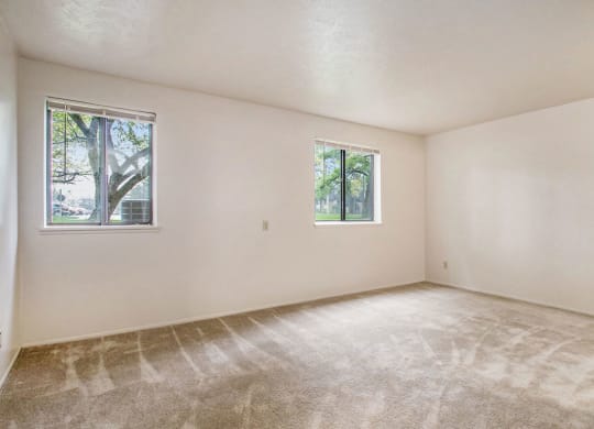 a bedroom with two windows and a carpeted floor at Hickory Village Apartments, Indiana, 46545