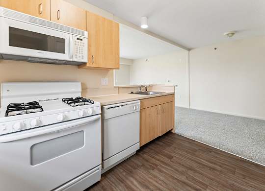 A kitchen with a white stove and microwave above it at Hunters Pond Apartment Homes, Champaign, IL