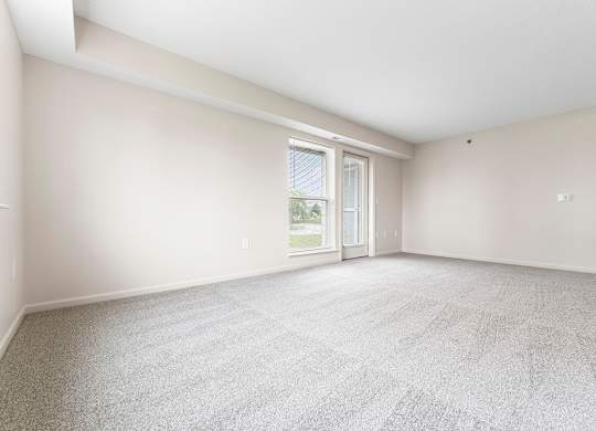 End style living room with a large window and a door  at Hunters Pond Apartment Homes, Champaign, IL, 61820