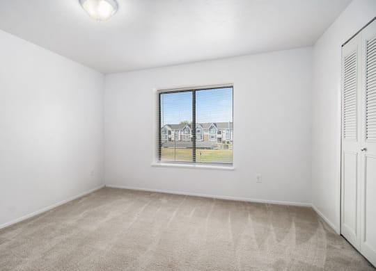 an empty living room with a large window at Hurwich Farms Apartments South Bend, IN