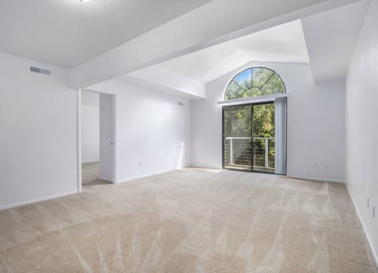 an empty living room with a large window and white walls at Hurwich Farms Apartments South Bend, IN