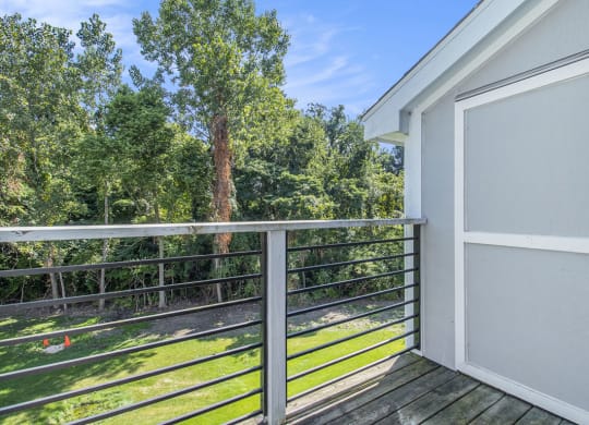 a balcony with a door and a view of the woods at Hurwich Farms Apartments South Bend, IN
