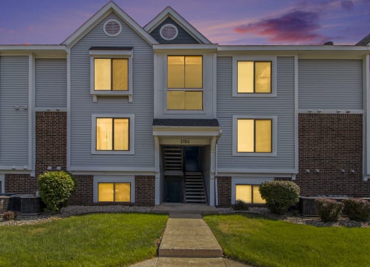 the front of an apartment building at dusk at Hurwich Farms Apartments, Indiana