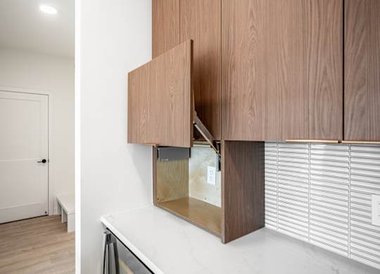 A white door is in a hallway with a white wall and a wooden cabinet.