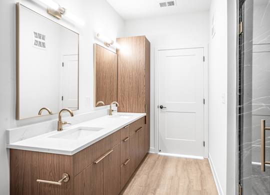A bathroom with a white counter top and brown drawers.