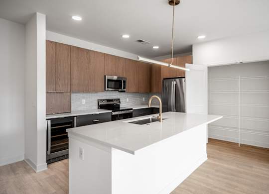 A modern kitchen with a white island and wooden cabinets.