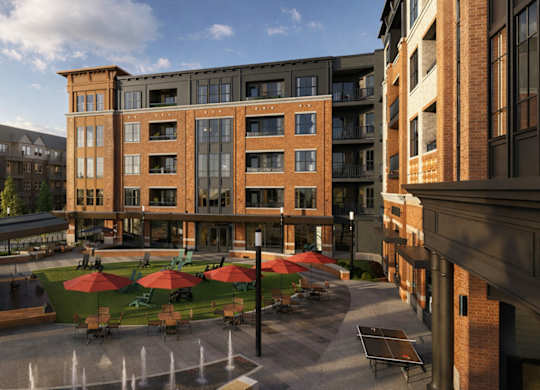 Central courtyard with splash fountain and colorful umbrellas at Icon on Main Apartments, Carmel, IN