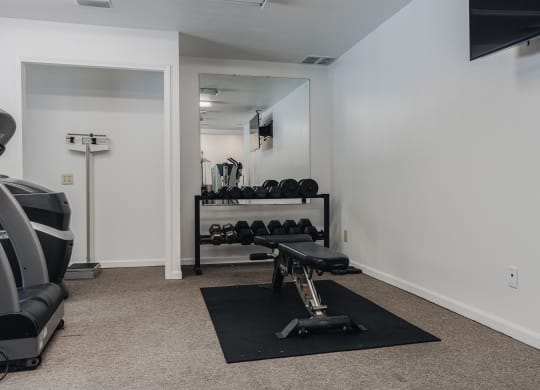 an exercise room with weights and a treadmill  at Polo Run Apartments, Greenwood, Indiana