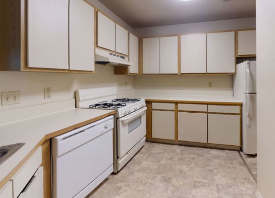 Kitchen with white appliances and stackable washer/dryer