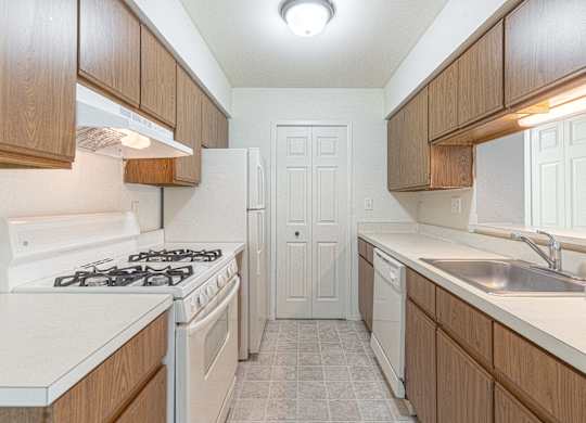 A kitchen with a white stove top oven and a white refrigerator.