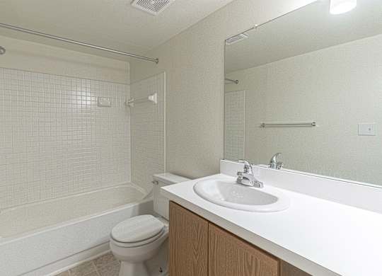 A white bathroom with a toilet, sink, and bathtub.
