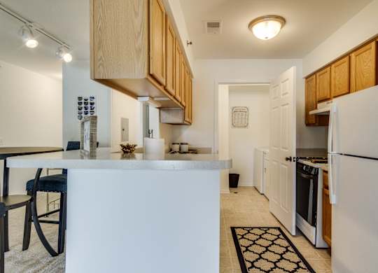 A kitchen with white appliances and wooden cabinets  at Northport Apartments, Macomb, MI, 48044