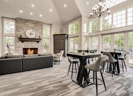 A modern dining room with a stone fireplace and a large table set for six at Westlake Apartments, Michigan