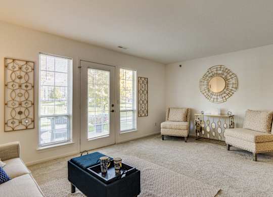 A living room with a black coffee table and two chairs